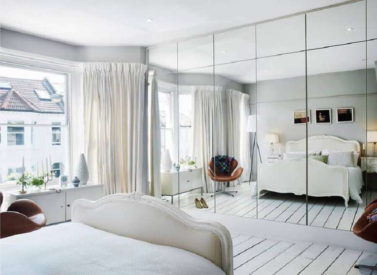 33. Decoração minimalista para quarto todo branco com guarda roupa grande com espelho – Foto: Desire to Inspire