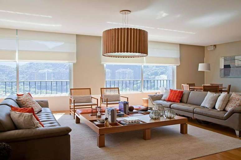 7. A sala de estar ampla conta com mesa de madeira baixa e proporcional, para harmonizar. Projeto por Maurício Nóbrega Arquitetura.