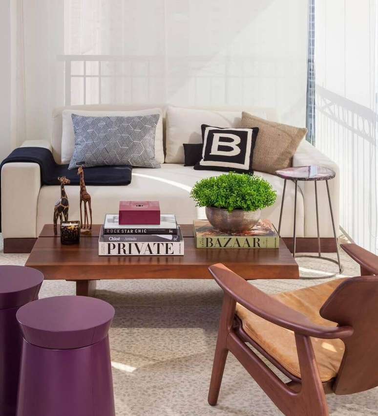 13. Os livros ficam muito bem na mesa de madeira na sala de estar. Projeto por AR Arquitetura.