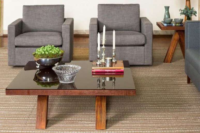 40. Esta mesa de madeira de centro ganha em modernidade com o tampo de vidro. Projeto de Codecorar
