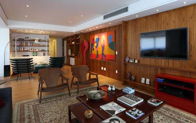 16. A mesa de madeira mais escura se destaca a outras cores do material na sala de estar. Projeto por Fernanda Renner.