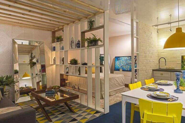 19. O studio ganha mesa de madeira dobr&aacute;vel na sala de estar. Projeto por Morar Mais por Menos Goi&acirc;nia 2017.