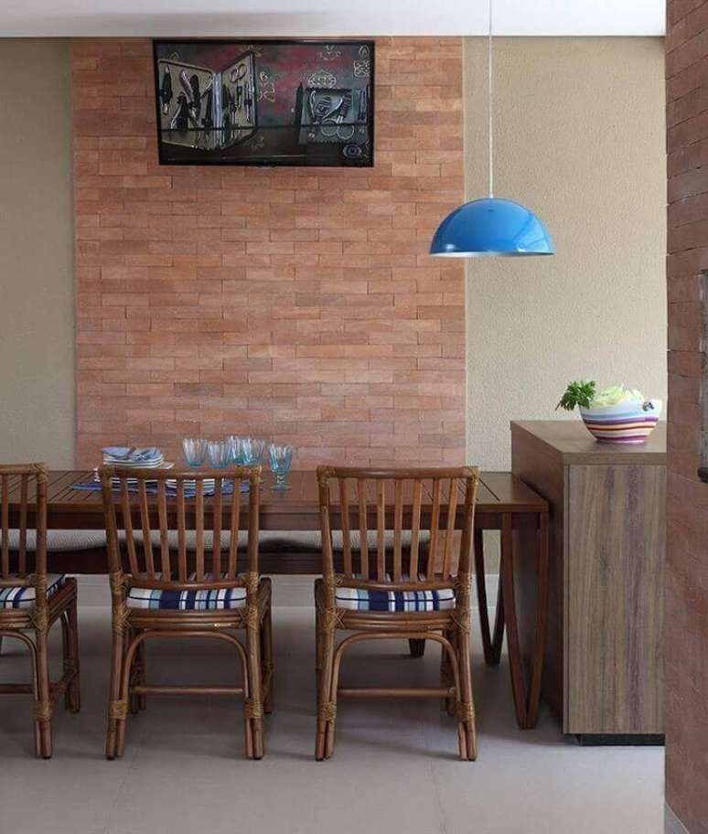 31. O ambiente para refeições tem mesa de madeira e detalhes azuis, para contrastar. Projeto por Rocha Andrade.