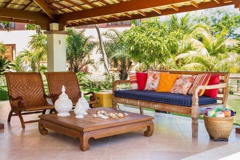 36. A mesa de madeira fica bem em &aacute;reas externas, mas deve ficar protegida da a&ccedil;&atilde;o do tempo. Projeto por Jamile Lima.