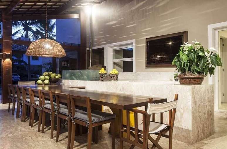 37. A área gourmet fica bonita e aconchegante com a longa mesa de madeira escura. Projeto por Nagila Andrade.