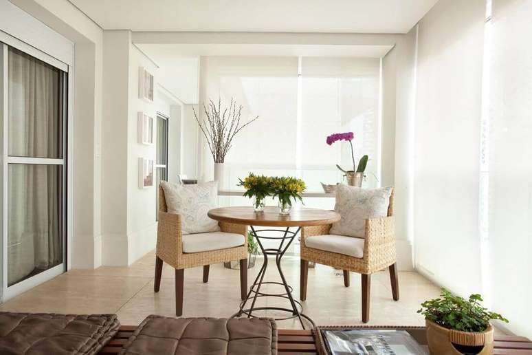 39. A pequena mesa de madeira redonda d&aacute; charme para o canto da varanda gourmet. Projeto por Liliana Zenaro.