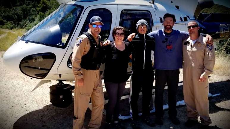 Krystal Ramirez (à esquerda), Hunter Whitson (ao centro) e Curtis Whitson (à direita) posam para foto com equipe de resgate