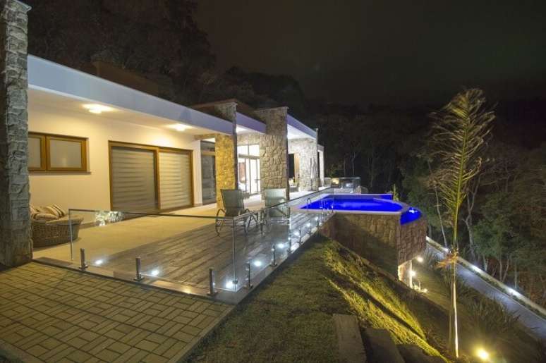 34. Casas com piscina com borda infinita iluminada no período noturno. Projeto por Manoela Lustosa