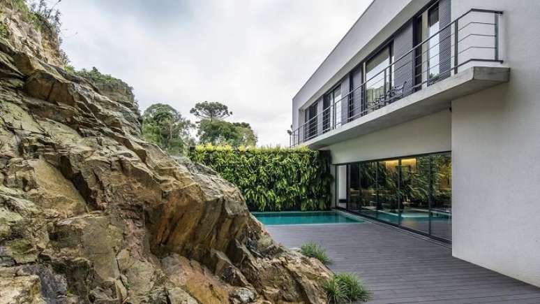 56. Casas com piscina, deck de madeira e rochas complementam a decora&ccedil;&atilde;o. Projeto por Jayme Bernardo Arquitetura e Design