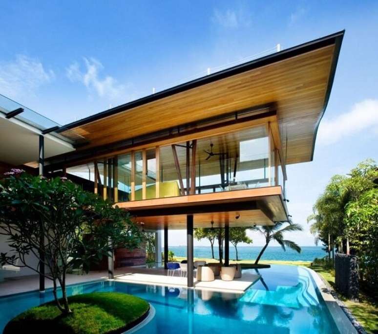 1. Casas com piscina, teto revestido com madeira e ilha com grama verde. Fonte: Revista Viva Decora