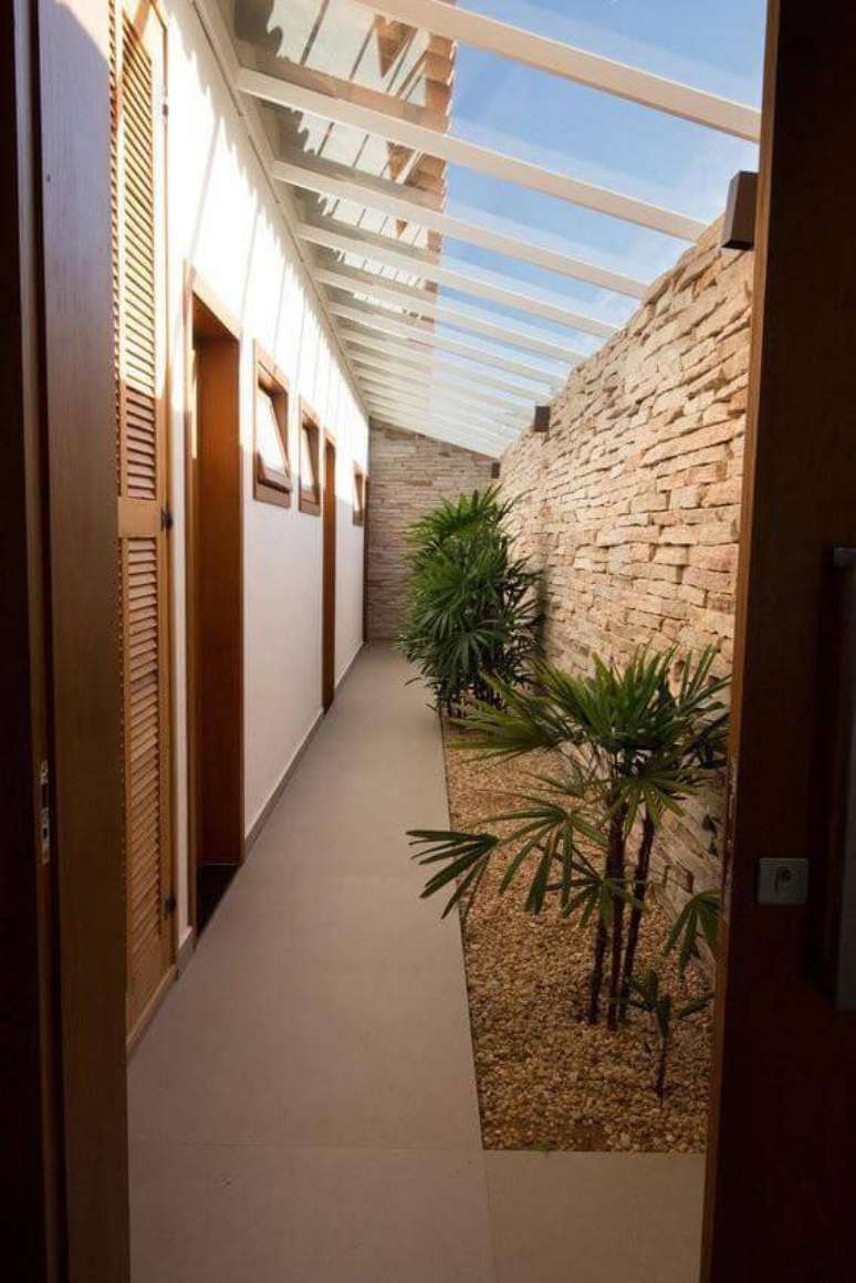 10. Combinar os cascalhos com a parede com pedras decorativas transforma o jardim no corredor. Projeto por Mutabile.