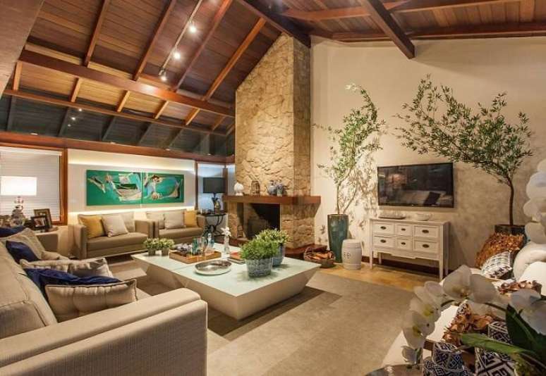 25. A área da lareira com pedras dá um efeito mais bonito para a sala de estar ampla. Projeto por Juliana Pippi.
