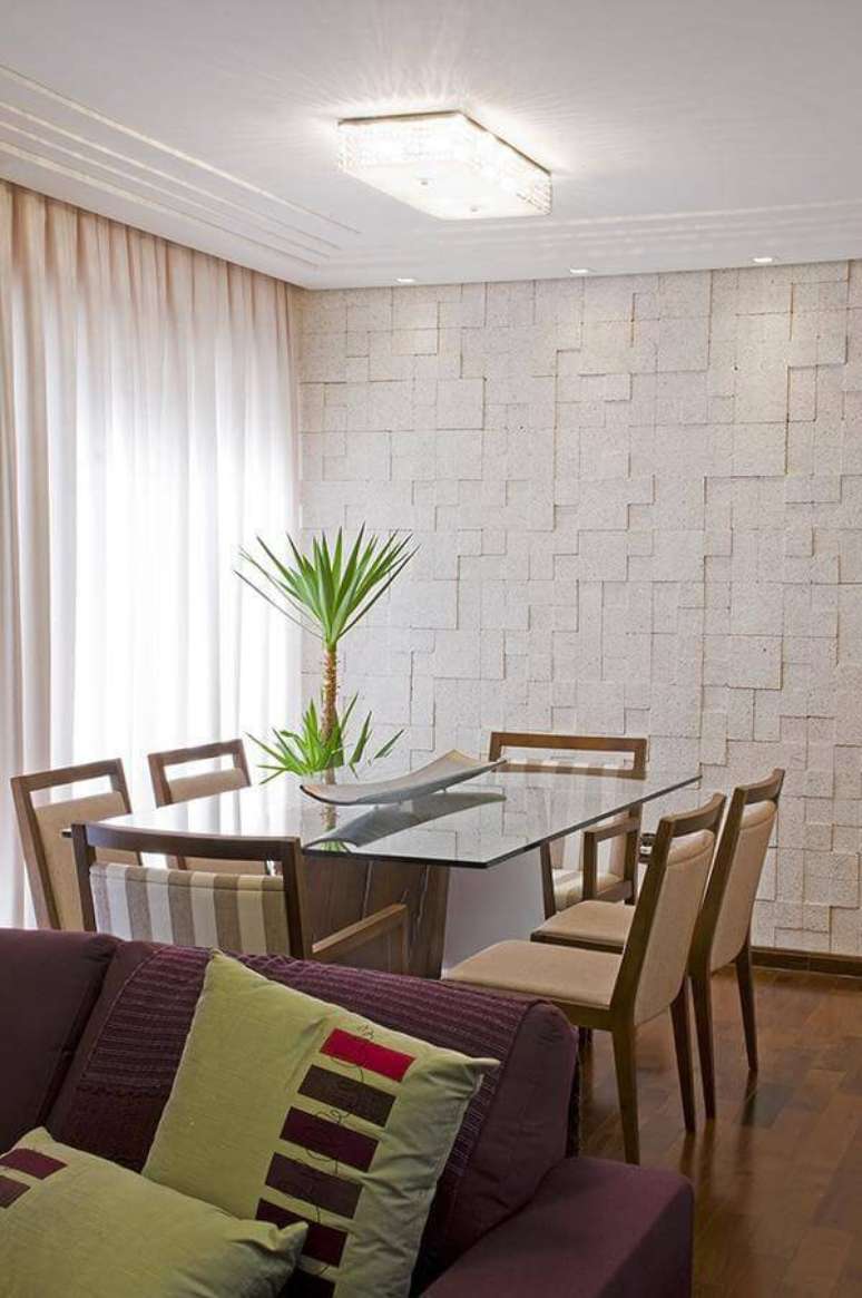27. A parede feita de pedras decorativas em mosaico faz a diferença na sala de jantar. Projeto por Natalia Pini.