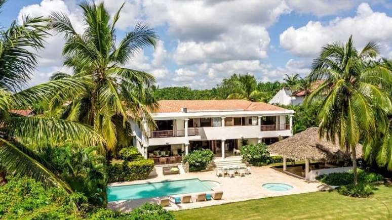 65. Piscina com mobili&aacute;rio de madeira e parede branca. Fonte: Revista Viva Decora