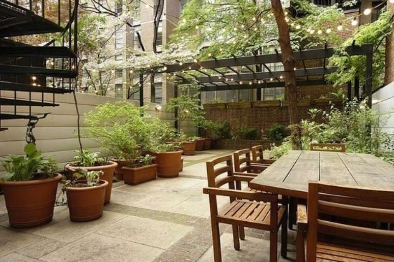 35. Piso para quintal combinando com as mesas rústicas e vasos de plantas – Por: Emme Interiores