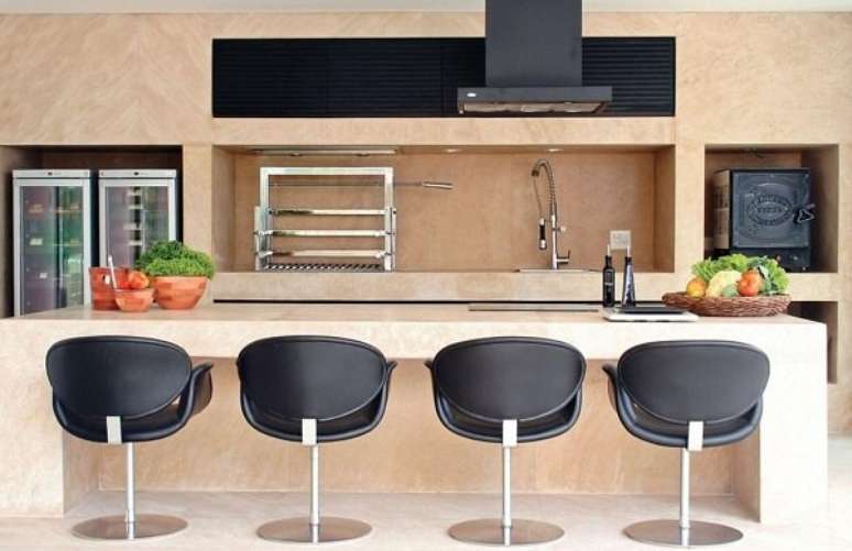 58- Área de churrasco com torneira gourmet e poltronas na cor preta. Projeto por A1 Arquitetura