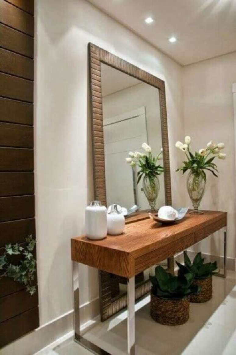 67. Hall de entrada decorada com aparador de madeira e espelho decorativo grande &ndash; Foto: Duca M&oacute;veis