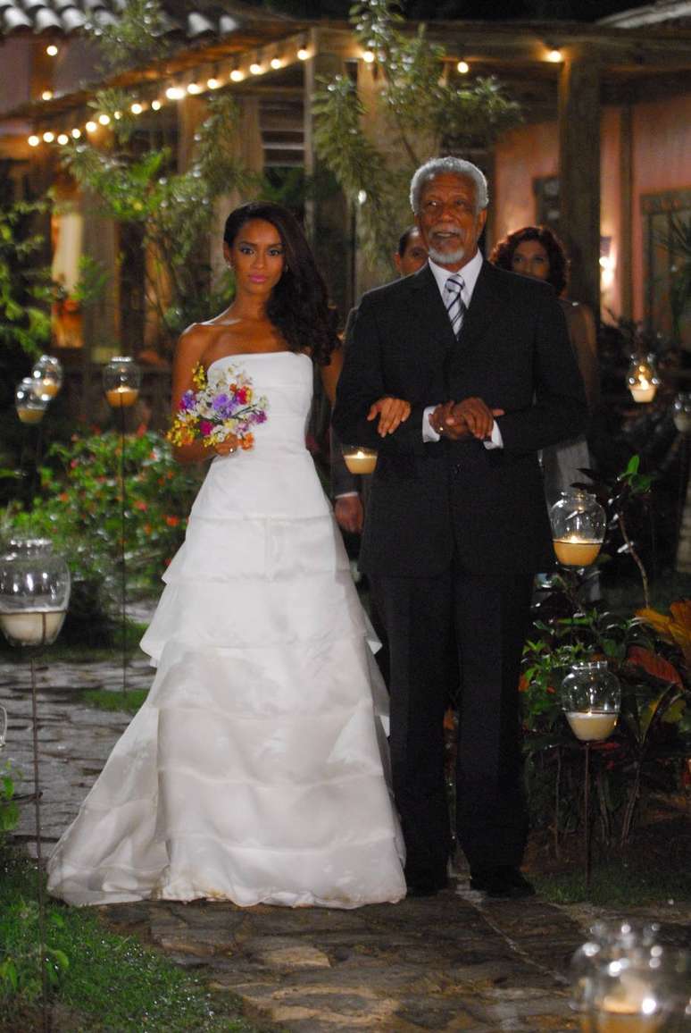 Helena (Ta&iacute;s Ara&uacute;jo) ao lado de Oswaldo (La&eacute;rcio de Freitas) em cena do casamento entre a personagem e Marcos (Jos&eacute; Mayer) em 'Viver a Vida'. &nbsp;