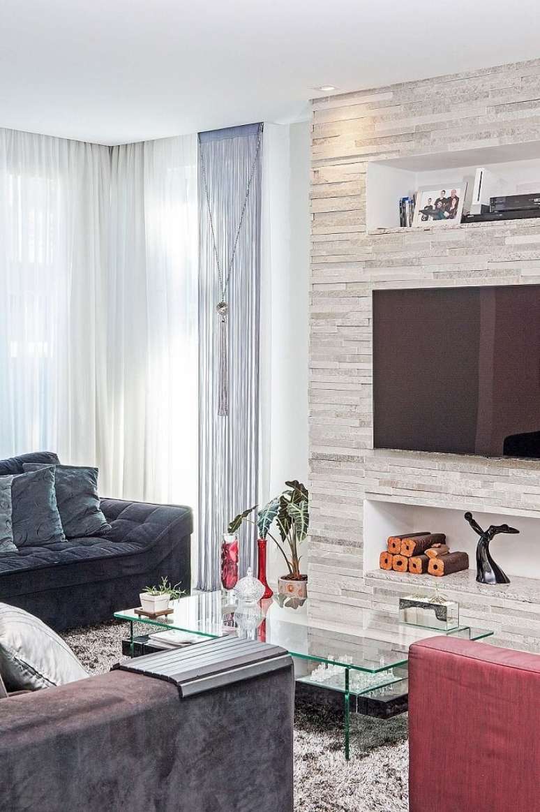 62. Sala de estar com parede feita em pedra S&atilde;o Tom&eacute;, a famosa pedra canjiquinha. Projeto por Patr&iacute;cia Azoni