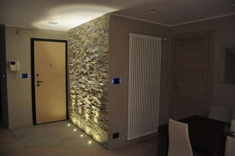 47. Apartamento com parede revestida com pedra S&atilde;o Tom&eacute;, conhecida tamb&eacute;m como pedra canjiquinha. Projeto por Gabriele Barotto