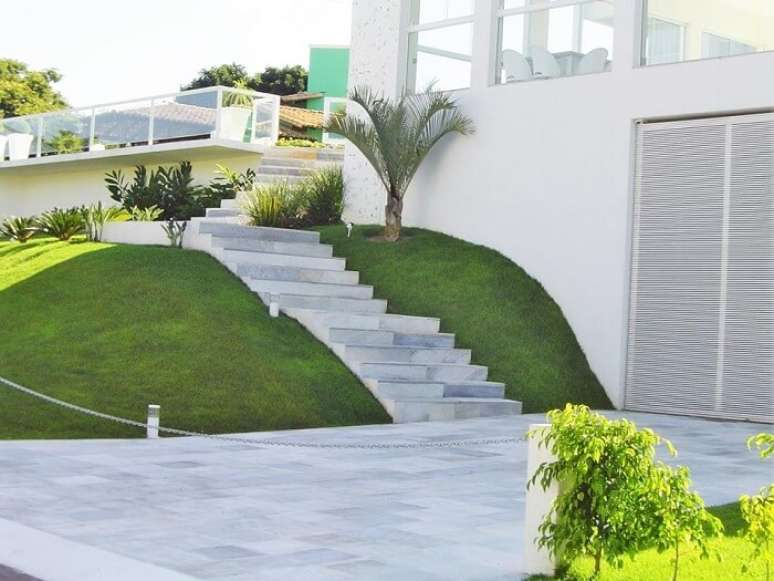 5. Escada feita com pedra S&atilde;o Tom&eacute; branca encanta a entrada da casa. Fonte: Pinterest
