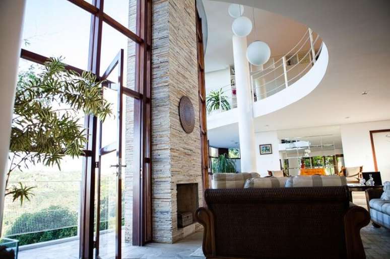 55. Lareira revestida com pedra canjiquinha, a famosa pedra tipo S&atilde;o Tom&eacute;. Projeto por Mascatenhas Arquitetos