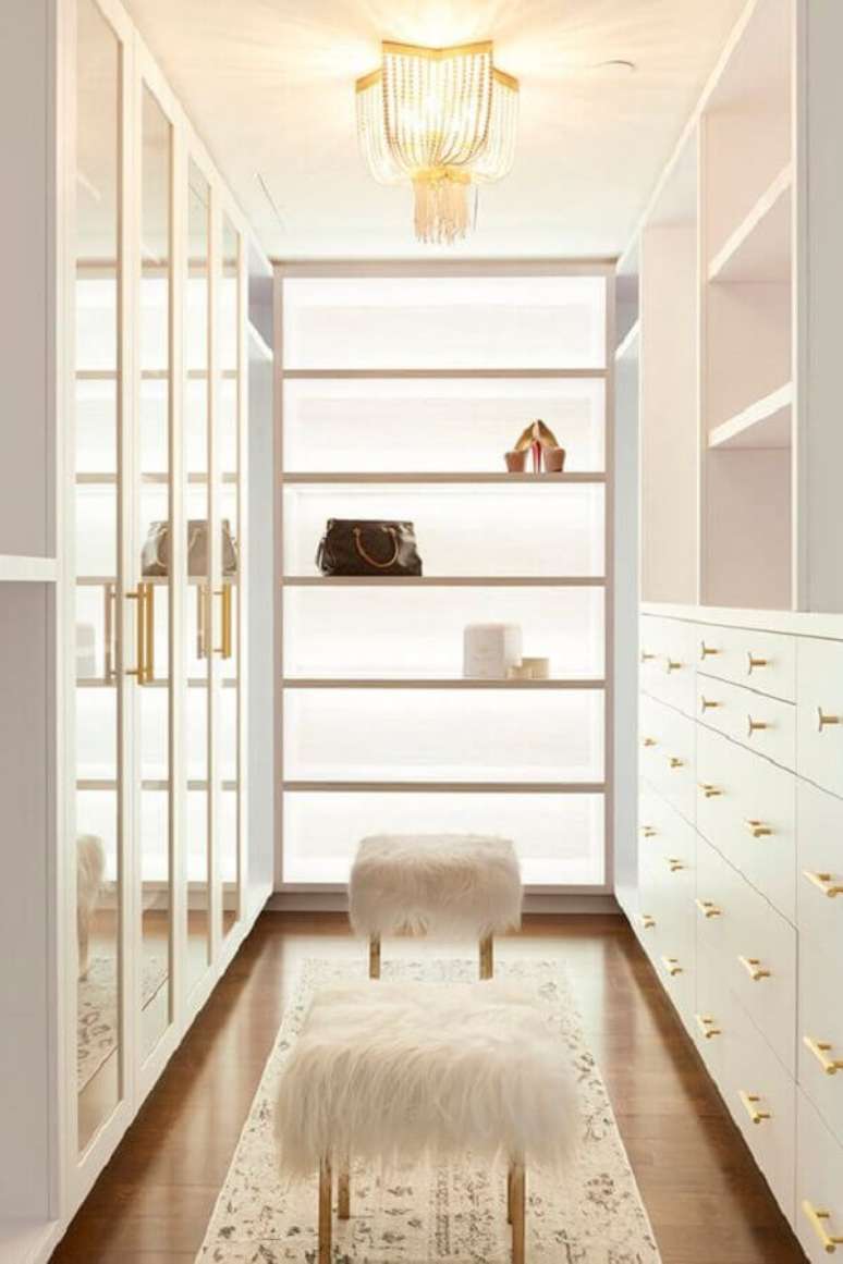 44. Os detalhes em dourado deixaram o closet luxuoso pequeno todo branco ainda mais sofisticado &ndash; Foto: Desire to Inspire