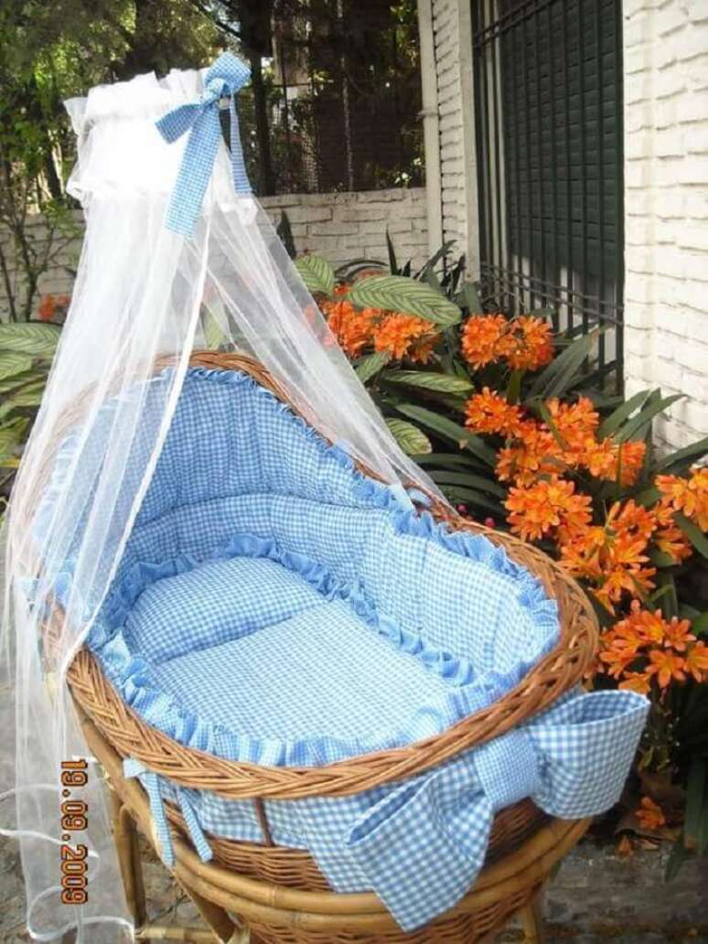 29. Ber&ccedil;o de vime com protetor em tons de branco e azul. Fonte: Pinterest