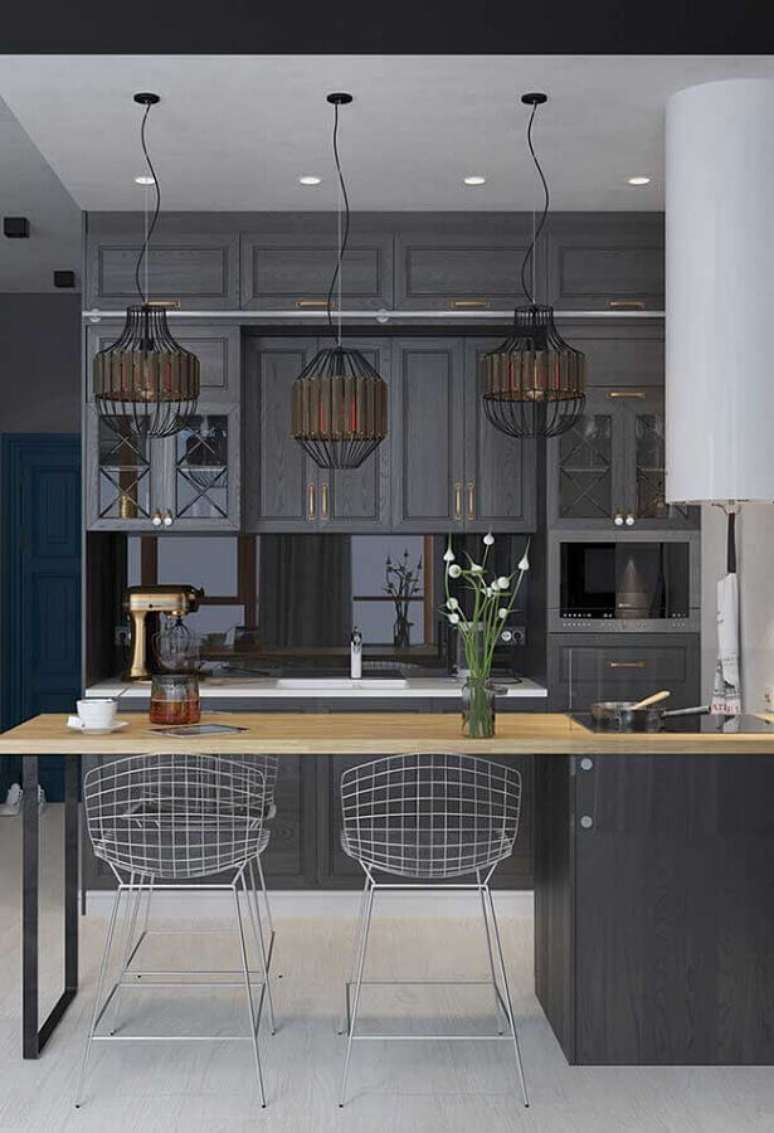 17. Decoração estilo industrial para cozinha com bancada de madeira e pendentes arrojados – Foto: Pinosy