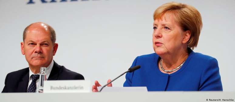 Angela Merkel  e o vice-chanceler Olaf Scholz durante o anúncio. Oposição verde e ativistas afirmam que pacote é tímido