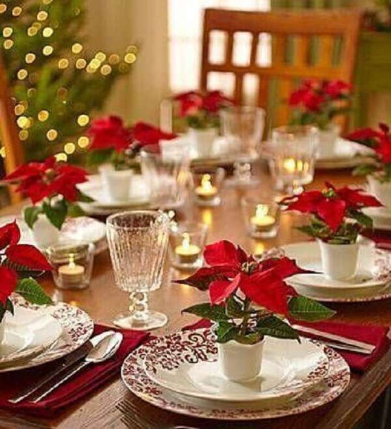 12- Sobre os pratos da mesa da ceia foram utilizados pequenos vasos com flor de natal artificial. Fonte: Pinterest