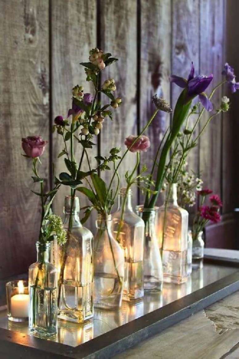 23. Decora&ccedil;&atilde;o feita com garrafas decoradas de vidro como vasos de flores