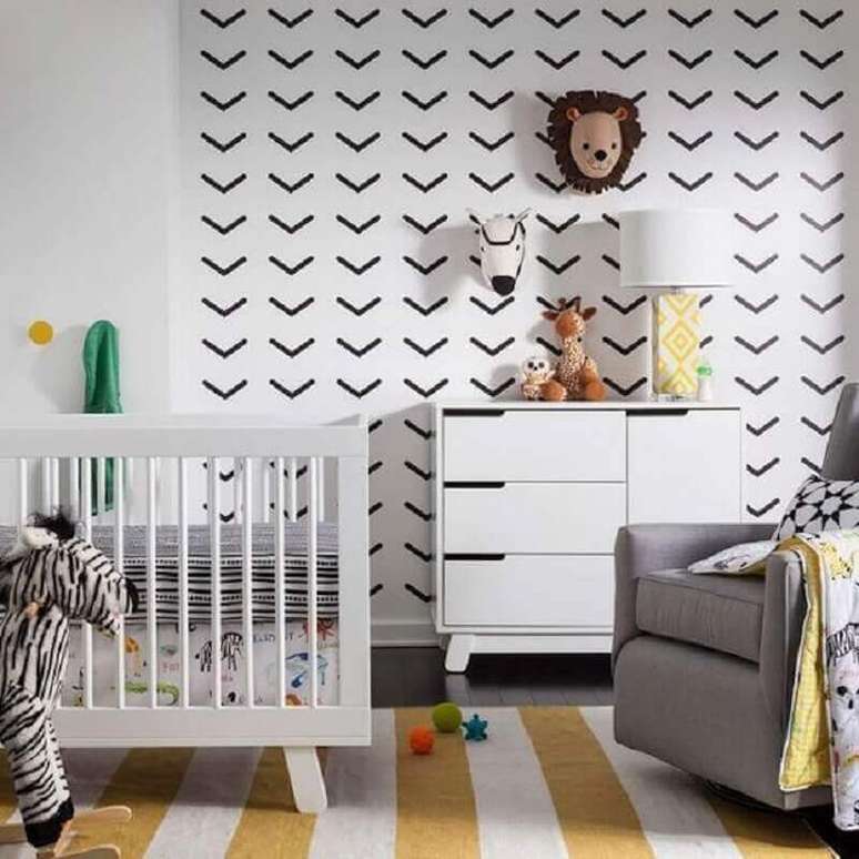 52. Parede decorada com fita isolante preta para quarto de bebê com tapete listrado – Foto: Yelp