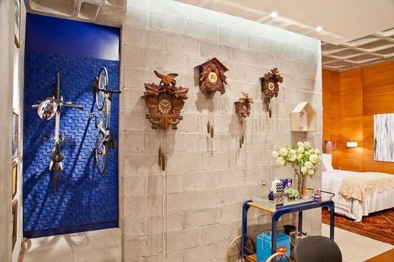 27. Sala de estar com v&aacute;rios modelos de rel&oacute;gio feitos em madeira. Projeto por Rico Mendon&ccedil;a