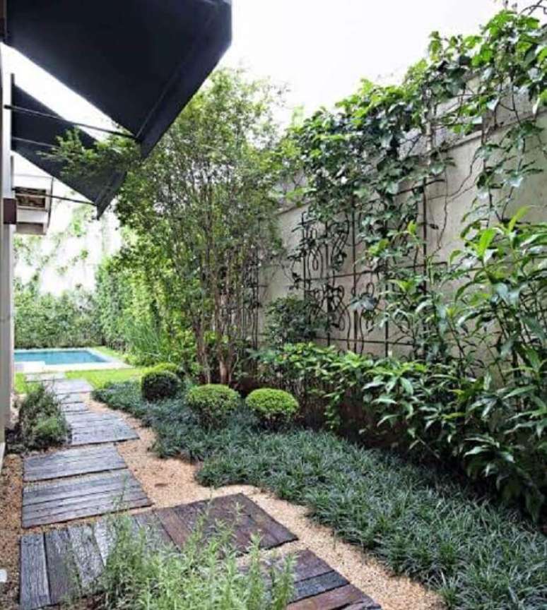 16. Área externa com chão forrado com grama preta e placas de madeira. Fonte: Casa e Jardim