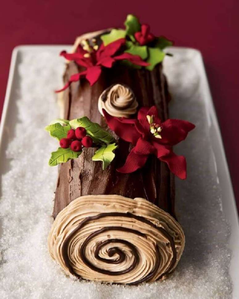 37. Bolo de Natal simples decorado em formato de tronco com flor de Natal em cima – Foto: Sweets by Demetria
