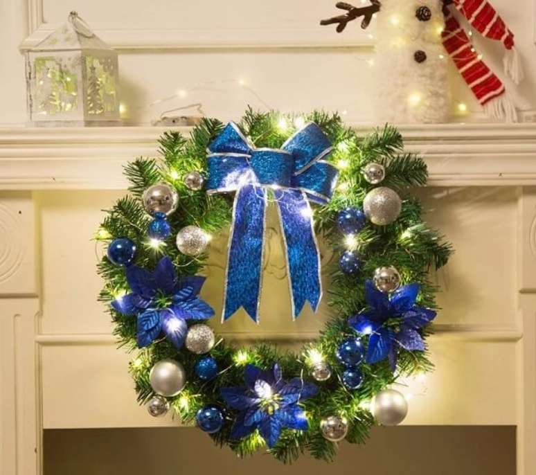 10. Guirlanda de Natal feita com flores artificiais e detalhes em azul. Fonte: Pinterest