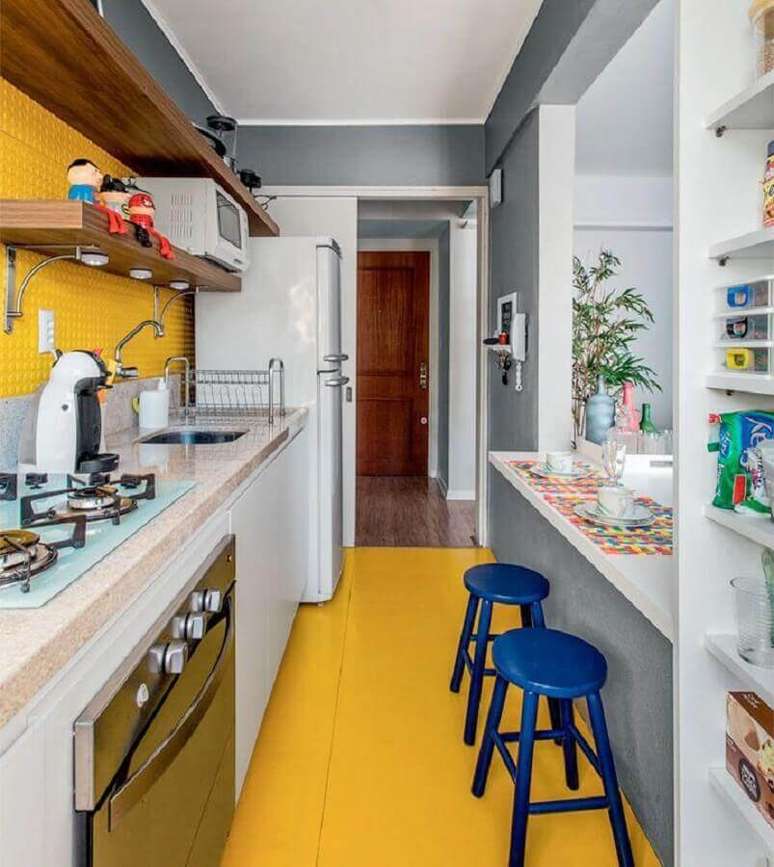 14. As banquetas azuis para cozinha amarela e branca deram um toque a mais de cor no ambiente – Foto: Espaço Casa