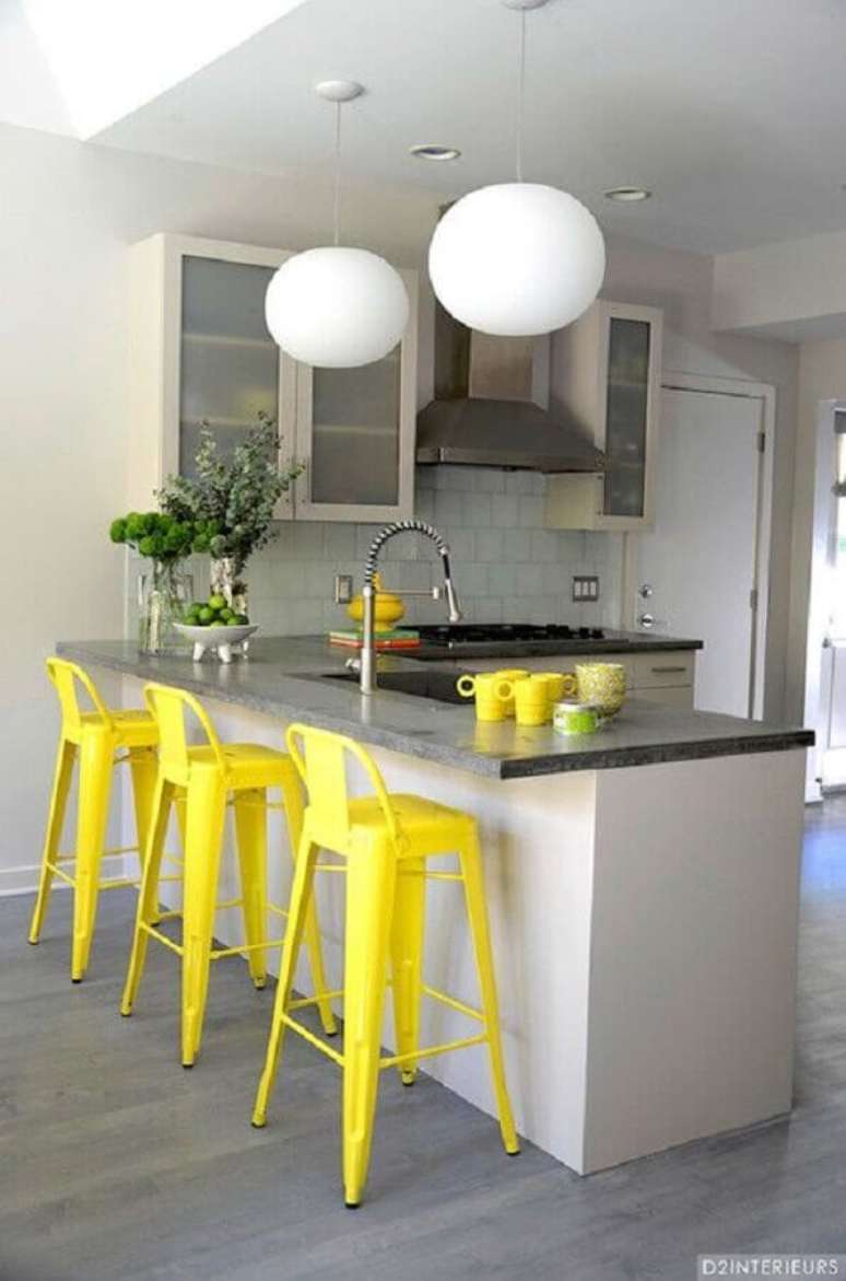 17. Banqueta para cozinha amarela e branca com pendentes redondos sobre a bancada – Foto: D2 Interieurs