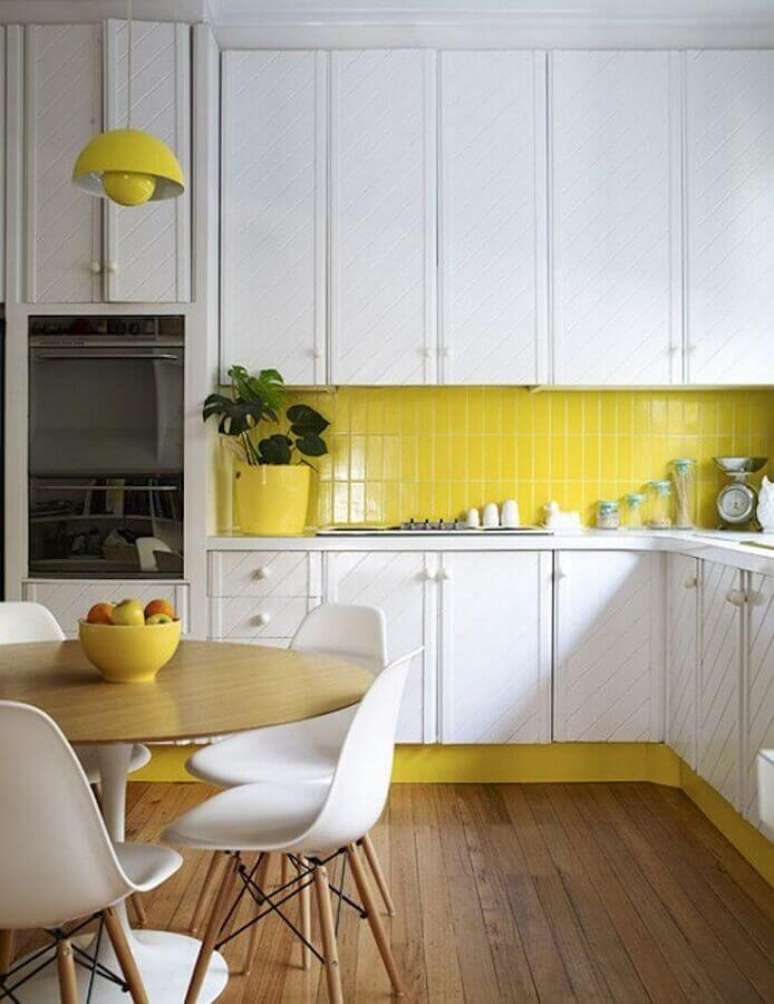 21. Cozinha amarela e branca decorada com mesa redonda de madeira e armários planejados – Foto: Homedit