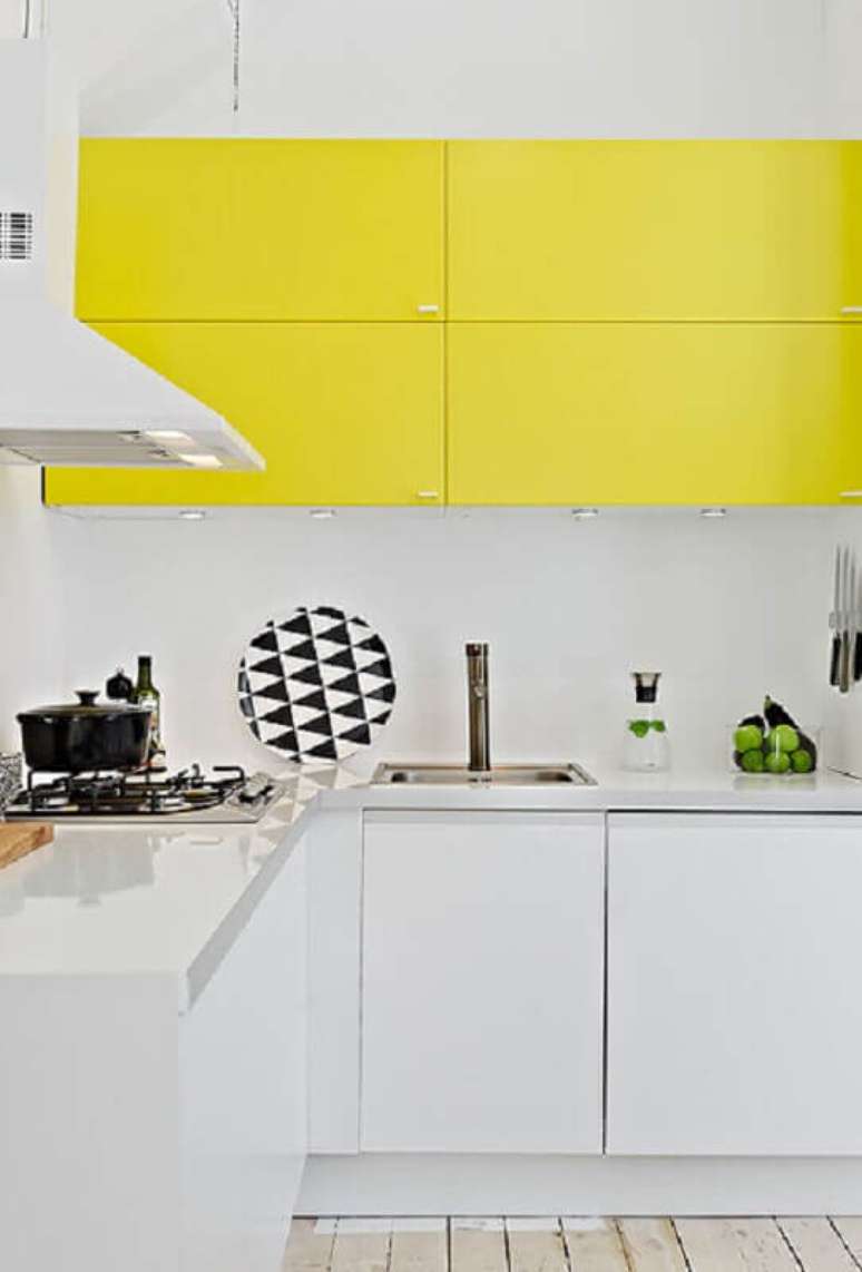 24. Cozinha amarela e branca planejada com luz embutida no armário aéreo – Foto: Pinterest