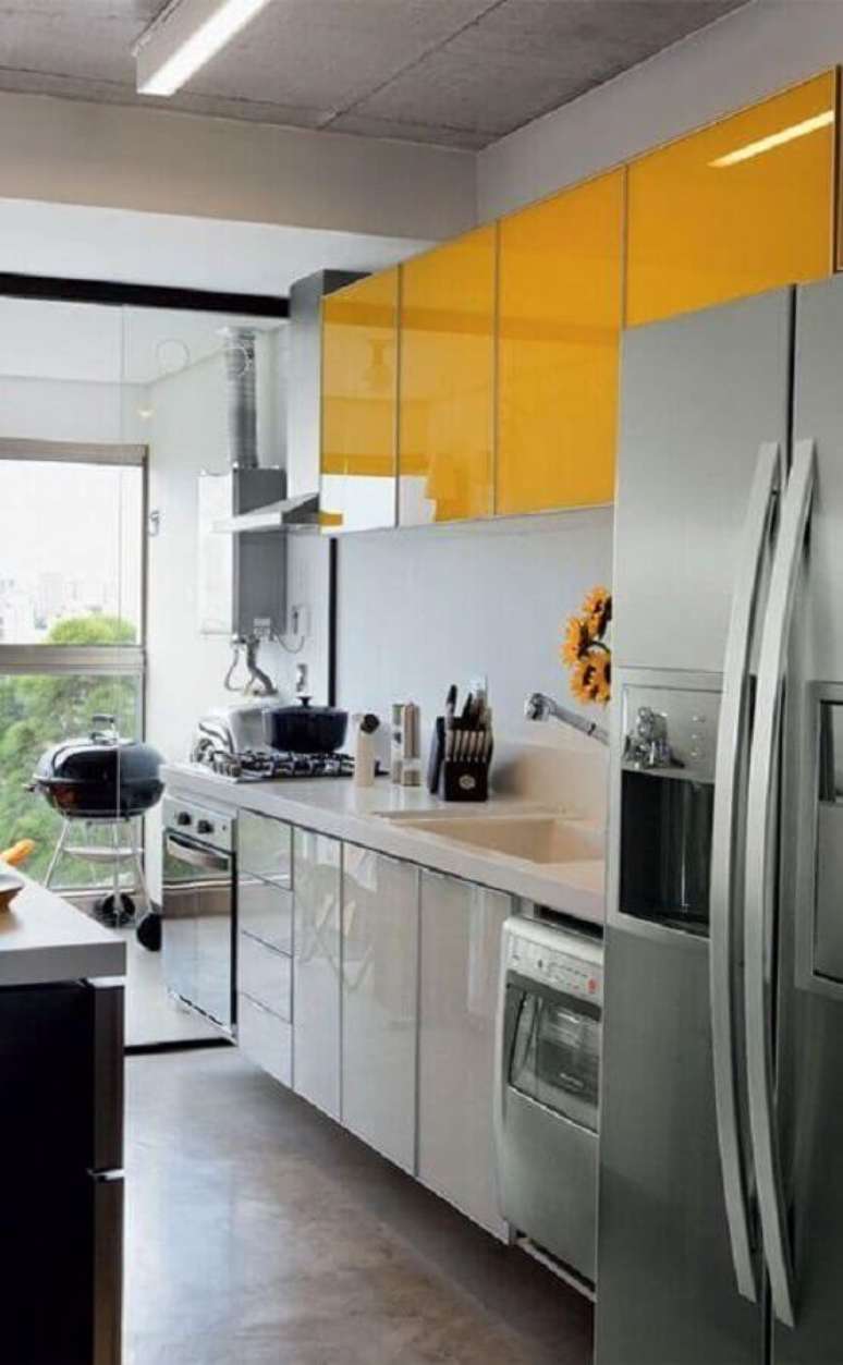 27. Decoração para cozinha compacta amarela com armários planejados e divisória de vidro para varanda – Foto: Blog Moroco