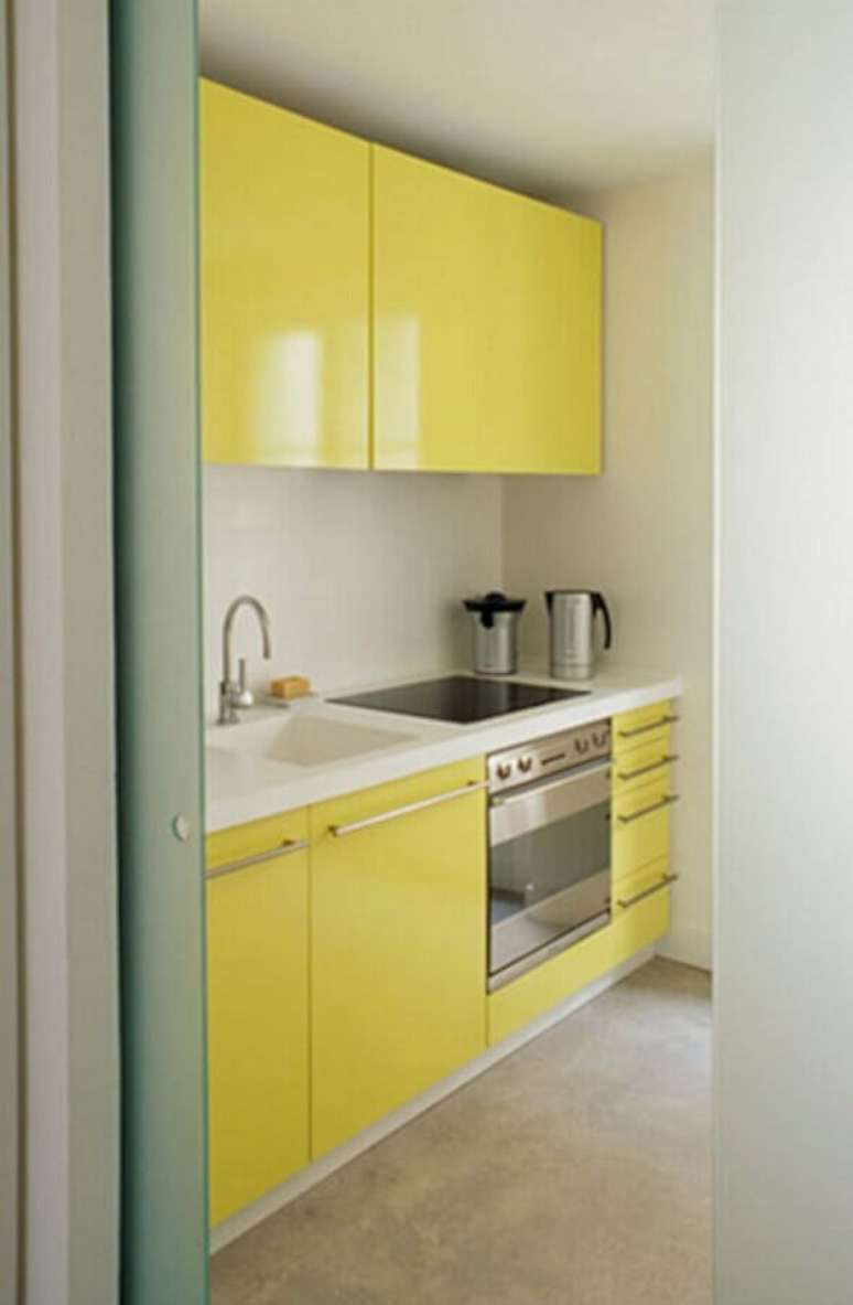31. Armário de cozinha amarelo planejado com bancada de branca e cooktop – Foto: Marko Mobilya