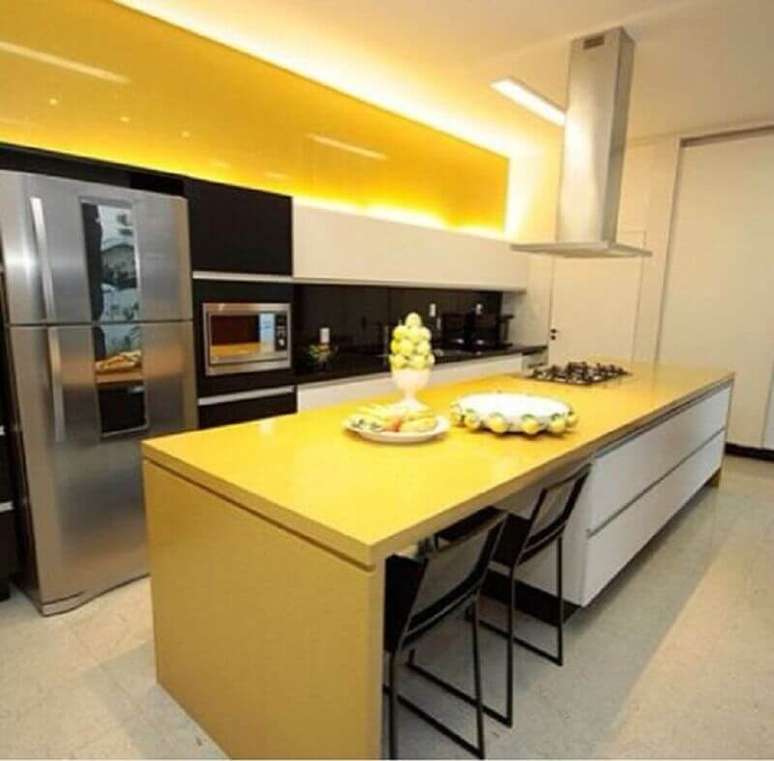 42. Decoração para cozinha amarela e preta moderna com ilha e coifa de teto – Foto: Pinterest