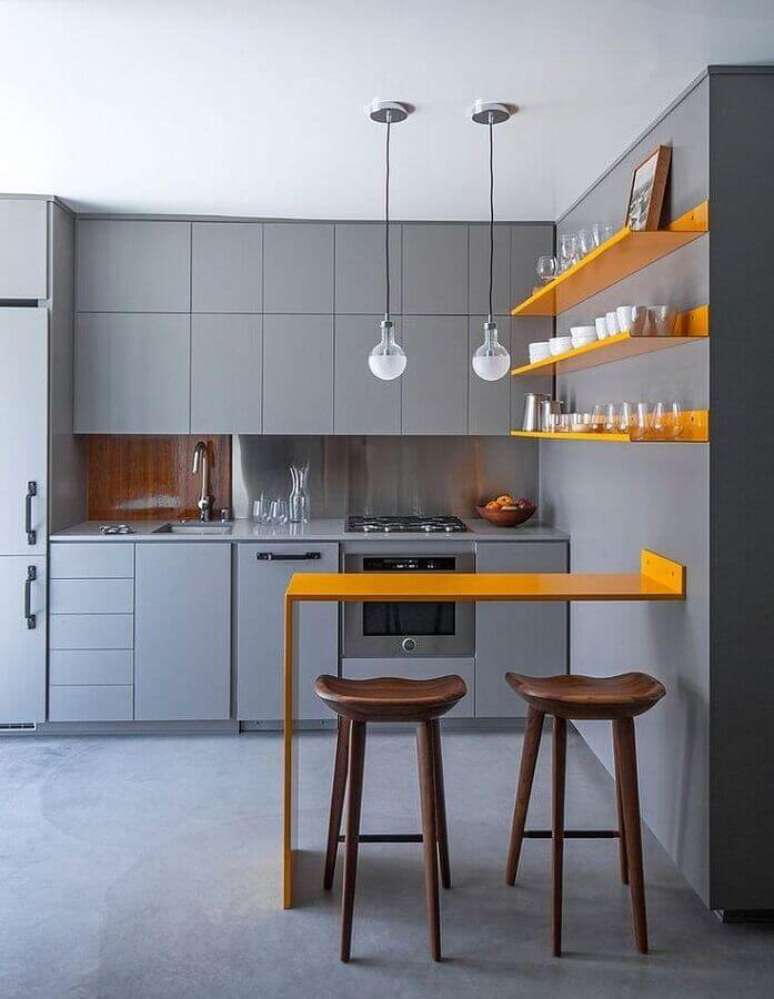 43. Cozinha planejada amarela e cinza com design moderno e pendentes minimalistas sobre pequena bancada com banquetas de madeira – Foto: Stylish Homes