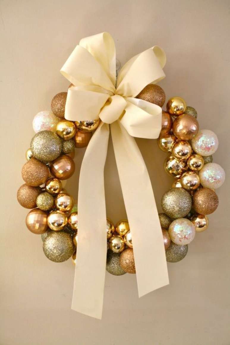 111. Guirlanda de natal com bolas douradas e laço de fita é lindo e criativo.