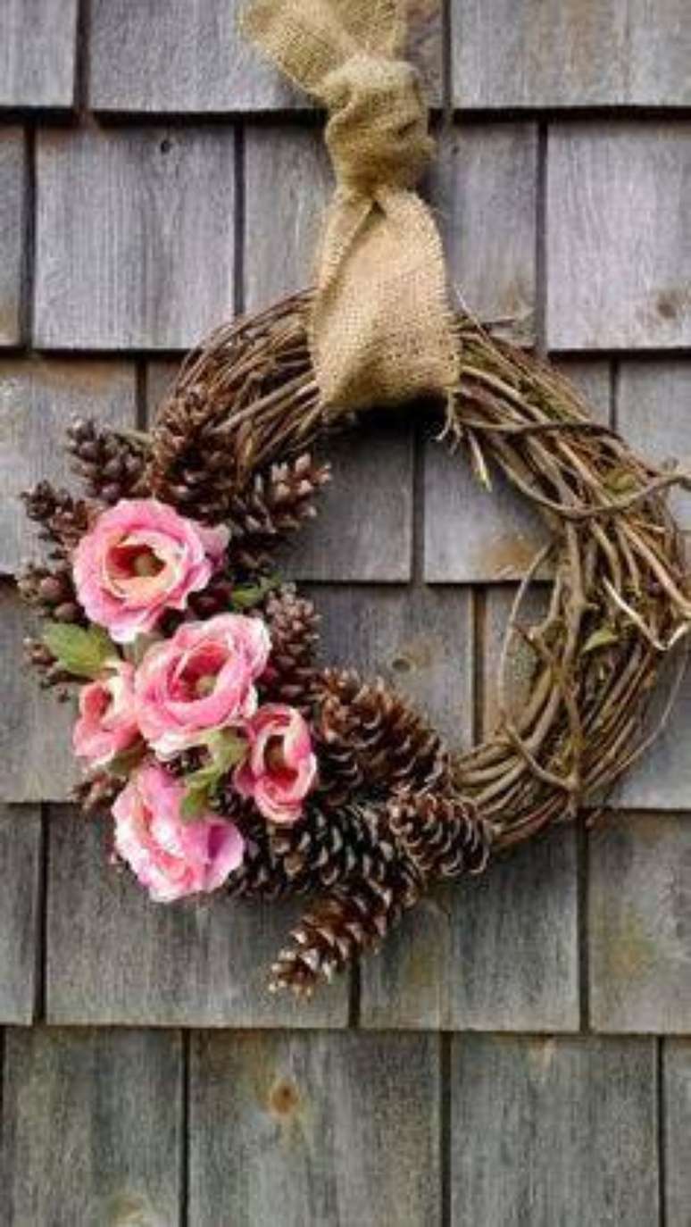 79. Guirlanda de Natal, com galhos, pinhas e flores, é perfeita para uma decoração rústica