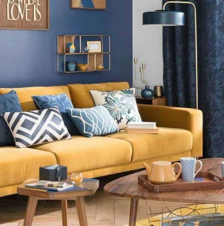 45. A sala de estar com sofá amarelo combina com os detalhes em azul – Por: Lojas Veneza