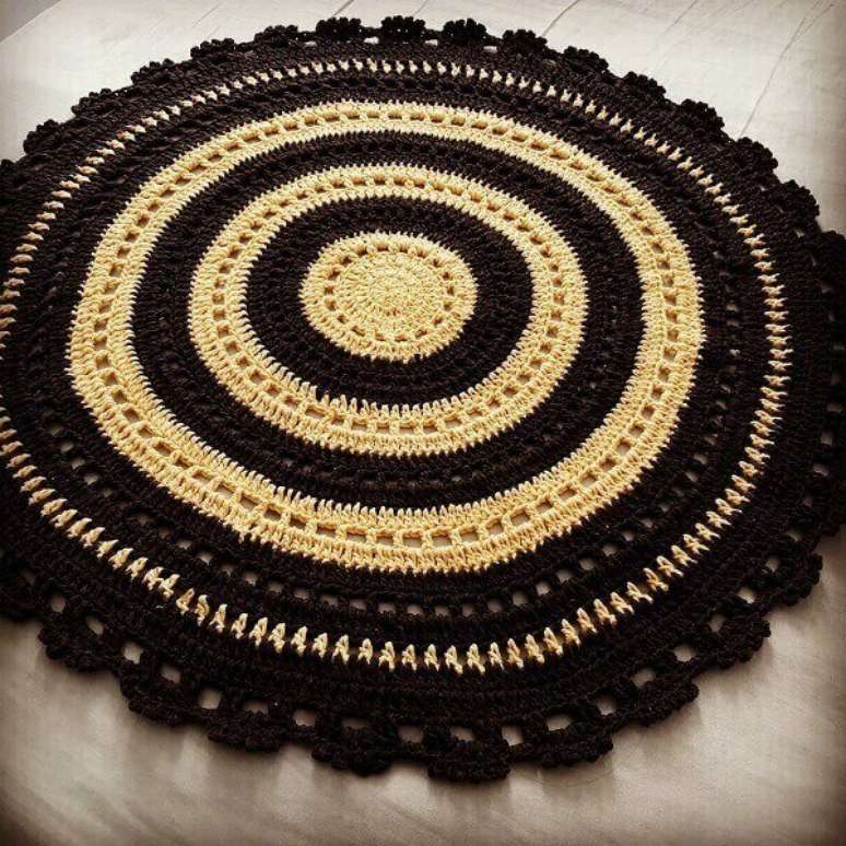36- Tapete de crochê redondo com anéis preto e amarelo. Fonte: Ateliê da Zielly