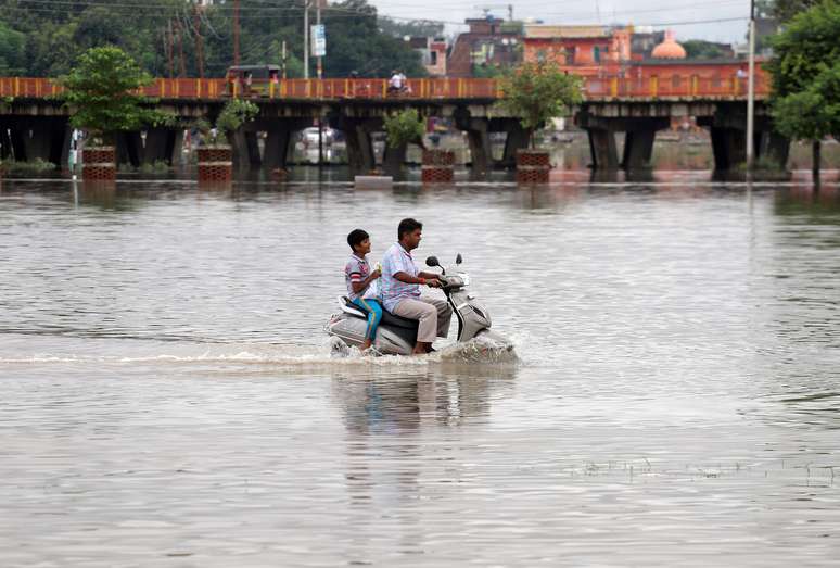 Homem e menino usam uma scooter em área alagada em Prayagraj, na Índia
29/09/2019
REUTERS/Jitendra Prakash